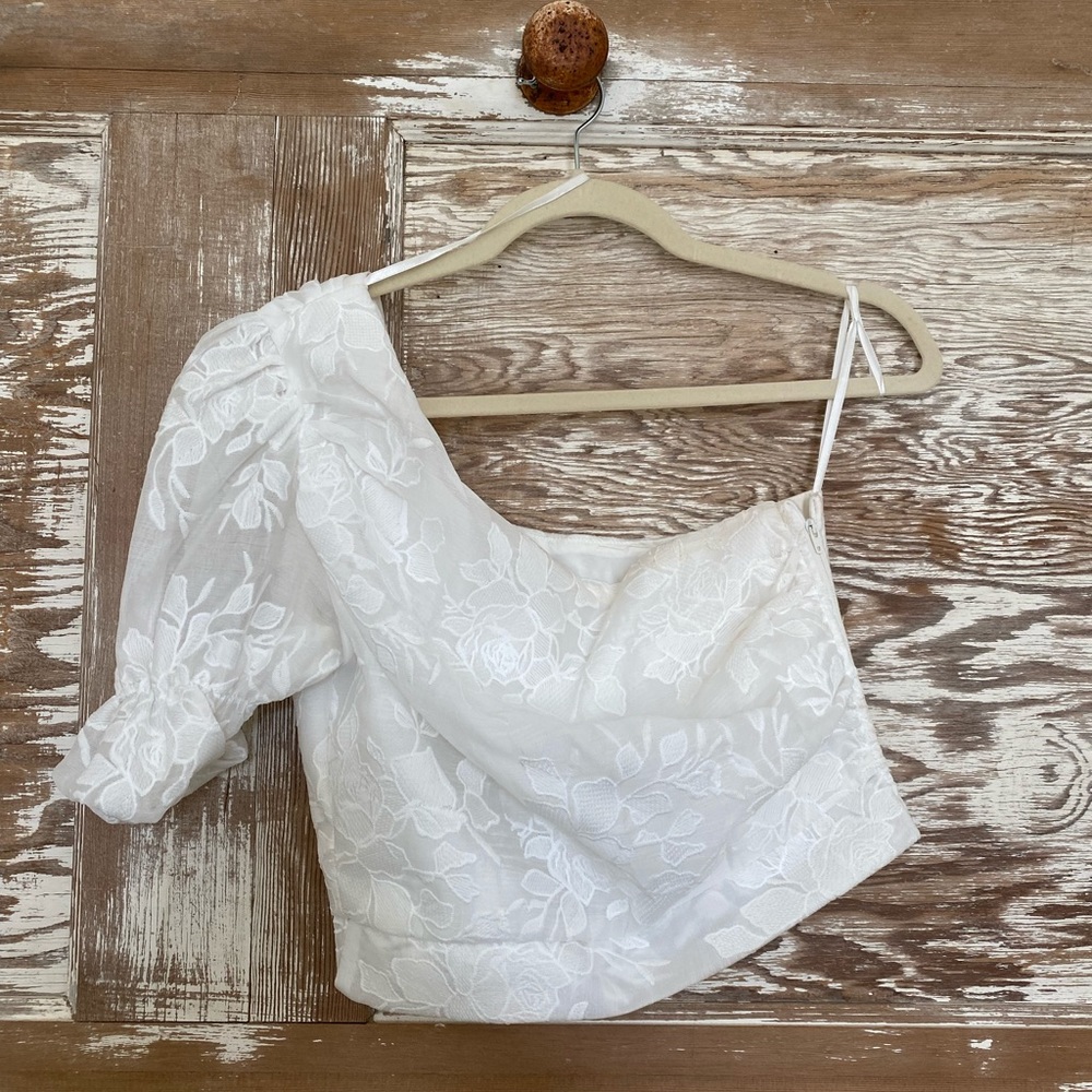 Beautiful white one shoulder Do+Be top. Floral lace design with puff sleeve